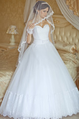 Fototapeta premium Beautiful young woman in white dress preparing herself to wedding 