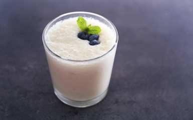 Obraz na płótnie Canvas Tasty yogurt decorated with blueberries on grey background