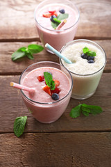Fresh strawberry and milk yogurts with berries on wooden background