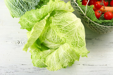 Savoy cabbage and other vegetables on wooden background