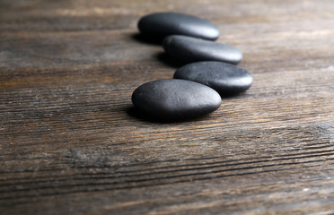 Pebbles in a row on wooden background