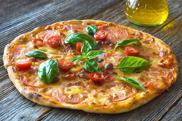 Pizza with mozzarella, tomato and basil leaves