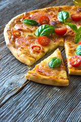 Pizza with mozzarella, tomato and basil leaves