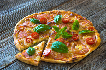 Pizza with mozzarella, tomato and basil leaves