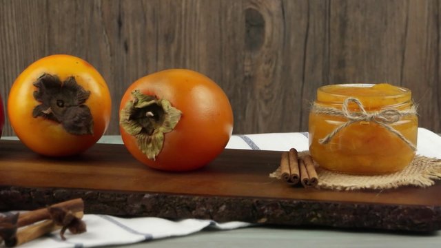 Fresh ripe persimmon on a wooden table.
