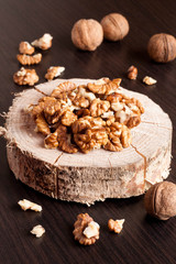 Walnut kernels and whole walnuts on wooden table