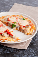 sliced pizza with tomato sauce, cheese and greens on a plate