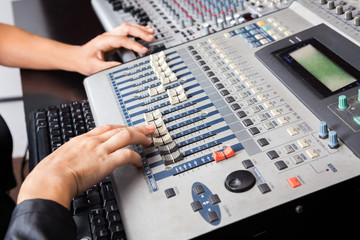 Professional's Hands Working On Audio Mixer In Recording Studio