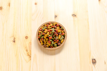 Dry dog food in wooden dish and wooden background