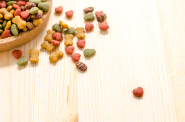 Dry dog food in wooden dish and wooden background