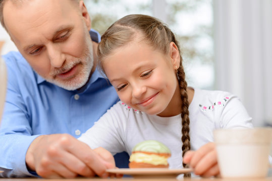 Grandfather And Little Girl Having Tea Party 