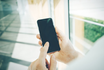 Smart phone holding in female hand on the blured background.