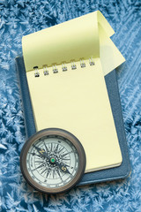 Vintage compass and blank yellow notepad