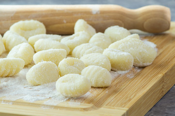 Gnocchi di patate fatti a mano, su tagliere con mattarello, gnocchi di patate su farina