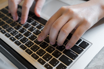 Closeup of business woman hand typing on laptop keyboard