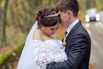 Bride and groom are walking in autumn forest 