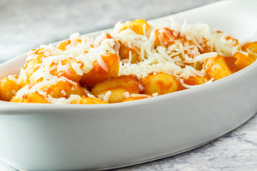 Gnocchi di patate al pomodoro nella terrnina con sugo di pomodoro, parmigiano e forchetta