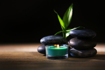 Spa stones and candles on dark background
