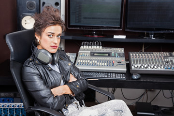 Woman Sitting With Arms Crossed At Mixing Desk