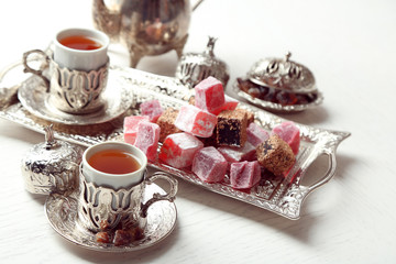 Antique tea-set with Turkish delight on table close-up