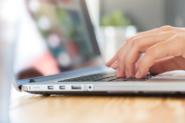 Obraz na płótnie Canvas Closeup of business woman hand typing on laptop keyboard