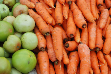 Fresh green tomatoes and carrots for sale