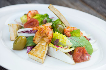 Prawns salad on a wooden background