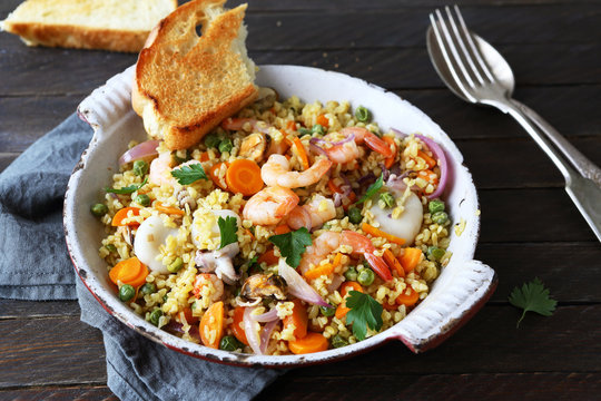 bulgur with roasted seafood in pan