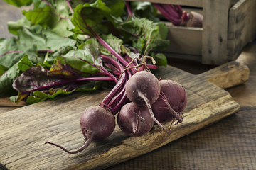 Bund erntefrische rote Rüben auf Holzbrett