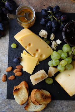 cheese and fruits on slate