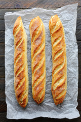 three baguette on white paper