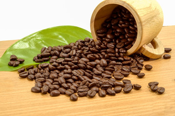 Coffee beans in a glass timber on a wooden surface.