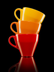 set of three red, orange and yellow cups on black background