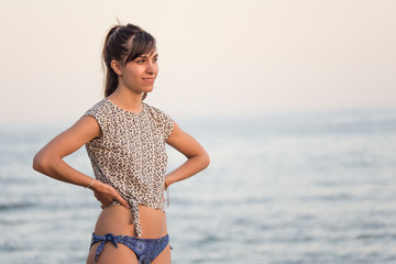 mujer en bikini sonriente de perfil mar de fondo