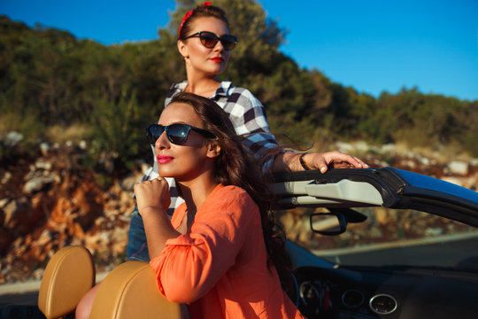 Two young girls having fun in the cabriolet outdoors