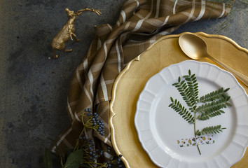 Holiday Gold place setting, napkin brown plaid, on grunge backgr
