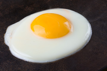Fried egg on the cast iron. close up