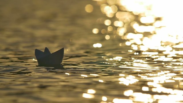 2 in 1 video! The toy paper boat on the surface water by the bright sunlight background. Real time capture. Shot with Red Cinema Camera