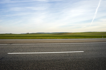 highway and field against blue sky