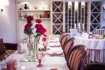 interior of the restaurant,  large table laid for  Banquet, decorated in Burgundy tones