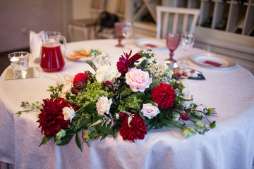 interior of the restaurant,  large table laid for  Banquet, decorated in Burgundy tones