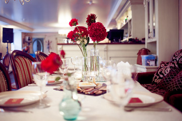 interior of the restaurant,  large table laid for  Banquet, decorated in Burgundy tones