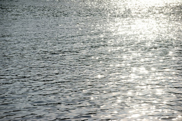Sonnenreflektionen / Die Draufsicht auf eine Licht reflektierende und abstrakte Wasseroberfläche