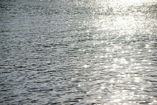 Sonnenreflektionen / Die Draufsicht auf eine Licht reflektierende und abstrakte Wasseroberfl&auml;che