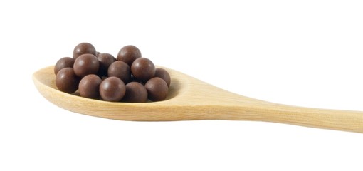 Wooden Spoon Full of Herbal Cough Lozenges Isolated on White