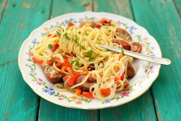 Spaghetti al Pomodoro in white plate with fork on wooden turquoi