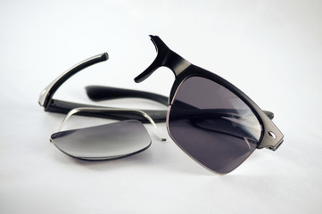 Black sunglasses broken, with lens detached, that need to be repaired by a specialist optician or...