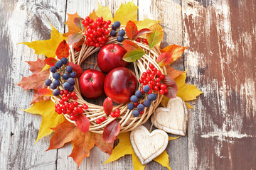 Wicker wreath with viburnum,, grapes, apples , maples leaves and hearts 