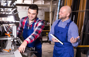 Workmen using a lathe to cut profiles