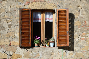 Fototapeta na wymiar Vintage windows with open wooden shutters and fresh flowers